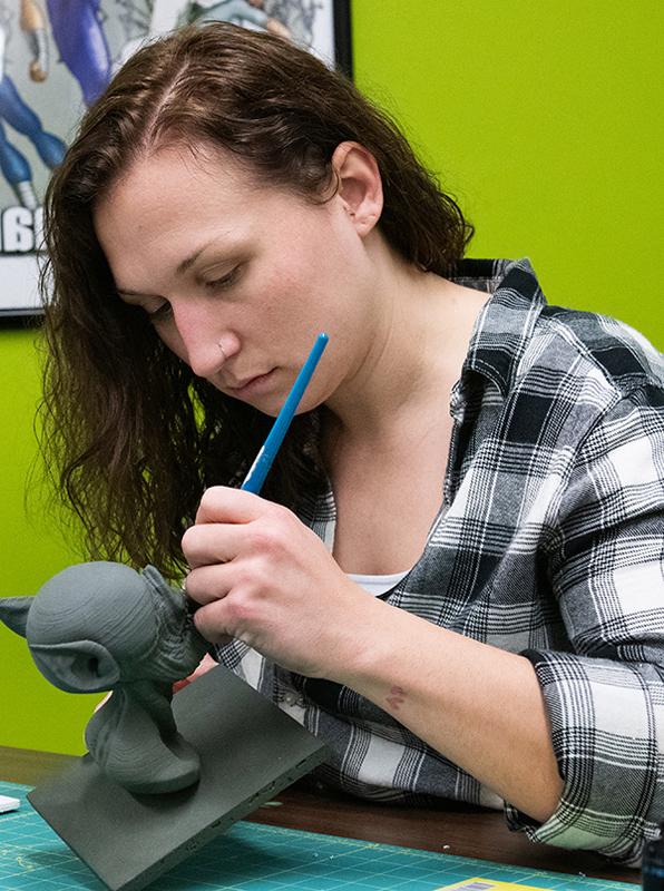 A student examines a dolphin 3D print.