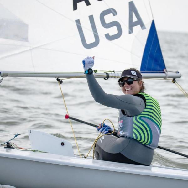 A sailing woman celebrating a win inside a sailing boat